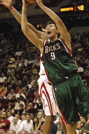 Houston Rockets' Yao Ming (back) tries to block Milwaukee Bucks Yi Jianlian (R) of China as he goes for a slam dunk in the fourth quarter of their NBA basketball game Nov. 9, 2007. (Xinhua Photo)
